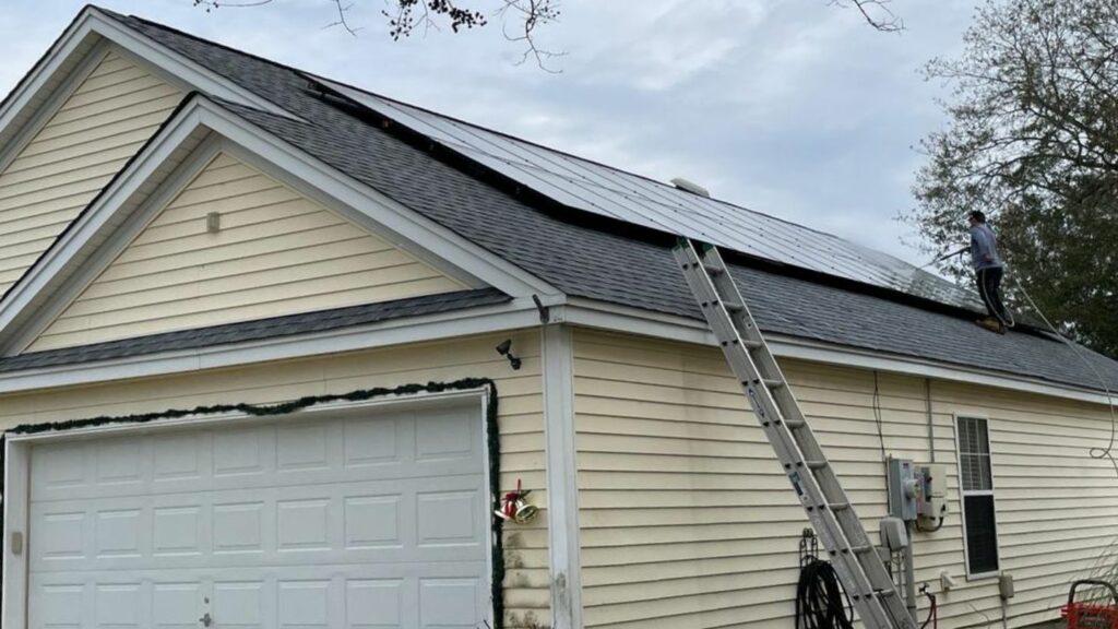 Yellow house with solar panels getting washed.